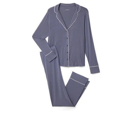 Ein marineblauer Pyjama mit weißer Paspelierung, bestehend aus einem geknöpften Oberteil und einer Hose.
