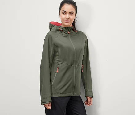 Frau trägt eine grüne 3-Lagen-Outdoorjacke.