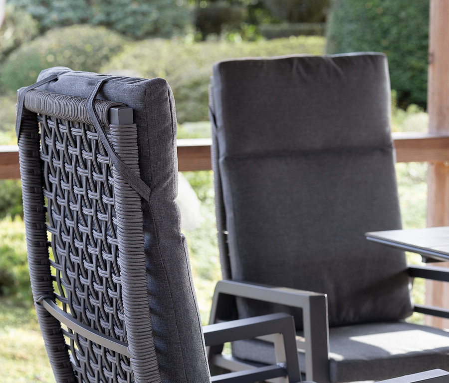 Zwei graue deVries Stühle mit Seilgeflecht auf einer Terrasse.