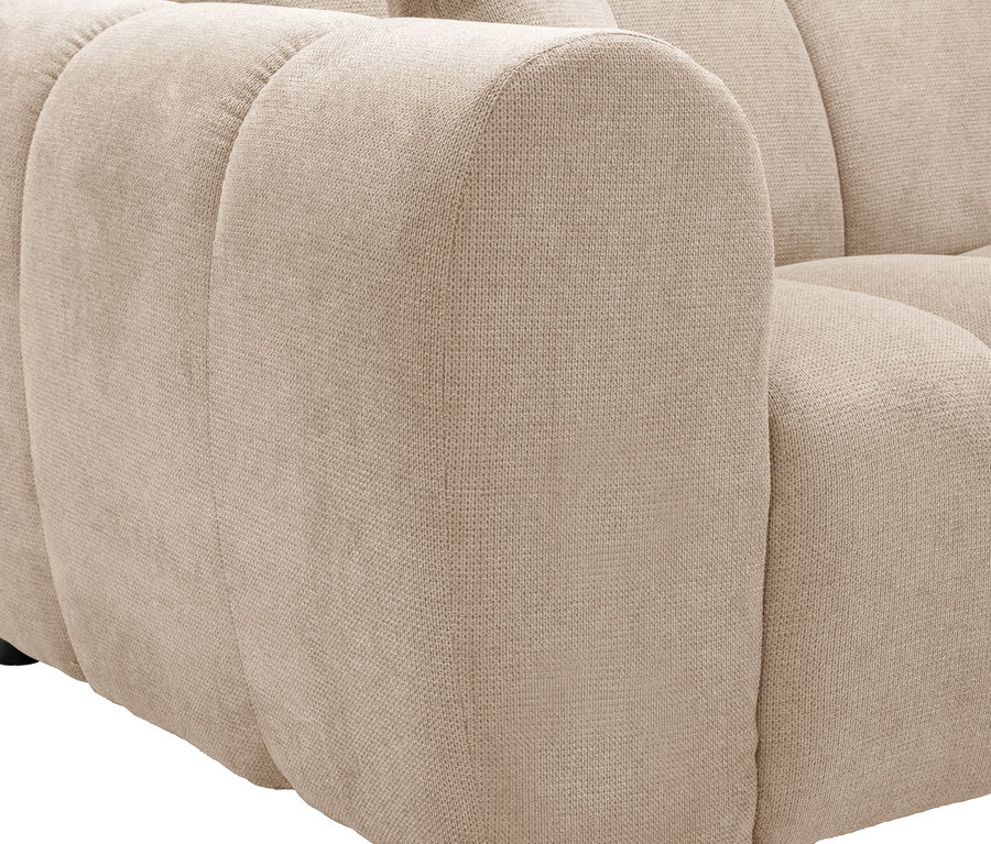 Detailansicht eines beigen Sofas mit abgerundeten Kanten und kleinen schwarzen Füßen.