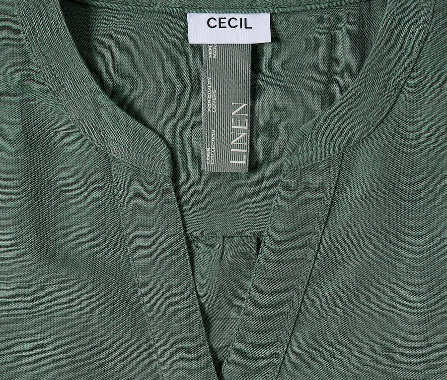 Nahaufnahme eines grünen Cecil-Leinenhemds mit V-Ausschnitt und Etikett.