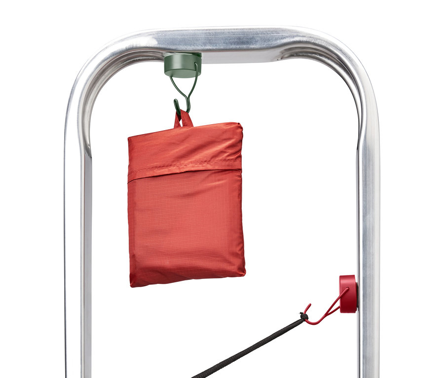 Eine orangefarbene Tasche hängt an einem silbernen Metallrahmen.