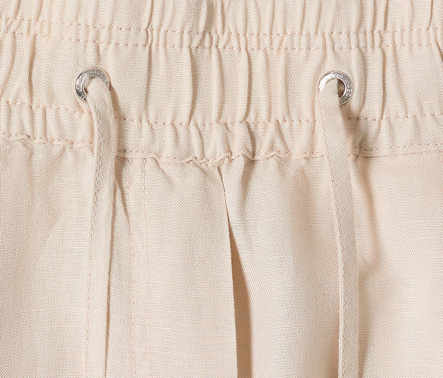 Detailaufnahme von beigen Hosen mit Tunnelzug und Kordel.