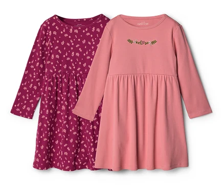 Zwei Baby-Jerseykleider: eines beerenfarben mit Blumenmuster, das andere rosa mit Blumenstickerei auf der Brust.