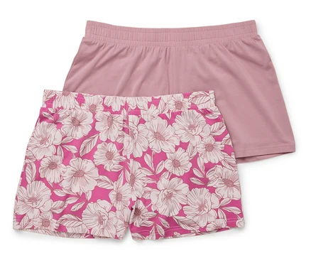 Zwei kurze Hosen liegen übereinander: eine unifarben rosa, die andere rosa mit weißem Blumenmuster.