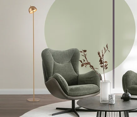 Modernes Wohnzimmer mit einem grünen Sessel, einem runden Couchtisch und einer goldfarbenen SCHÖNER WOHNEN-Kollektion Akku-Stehleuchte »Bellis«.