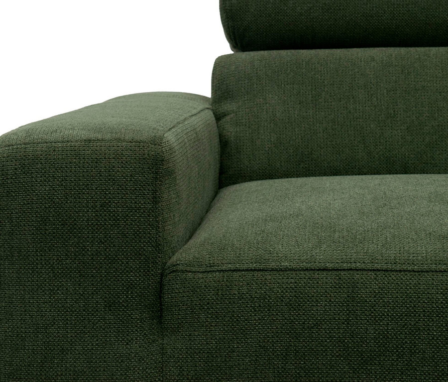 Nahaufnahme eines dunkelgrünen Sofas mit strukturiertem Stoff, das die Armlehne links sowie Sitzfläche, Rückenlehne und Kopfstütze rechts zeigt.