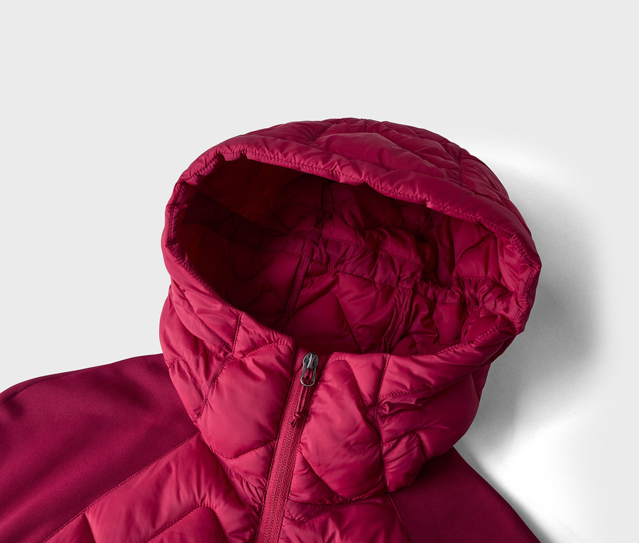 Nahaufnahme einer roten Steppjacke mit Kapuze, die den teilweise geschlossenen Reißverschluss zeigt. Die Jacke hat ein rautenförmiges Steppmuster am Körper und an der Kapuze, mit glatten Stoffeinsätzen an den Schultern.