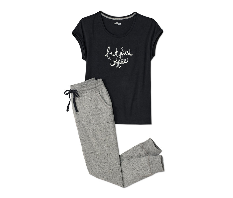 Ein Damen-Pyjama, bestehend aus einem schwarzen T-Shirt mit Aufschrift und einer grauen Jogginghose.