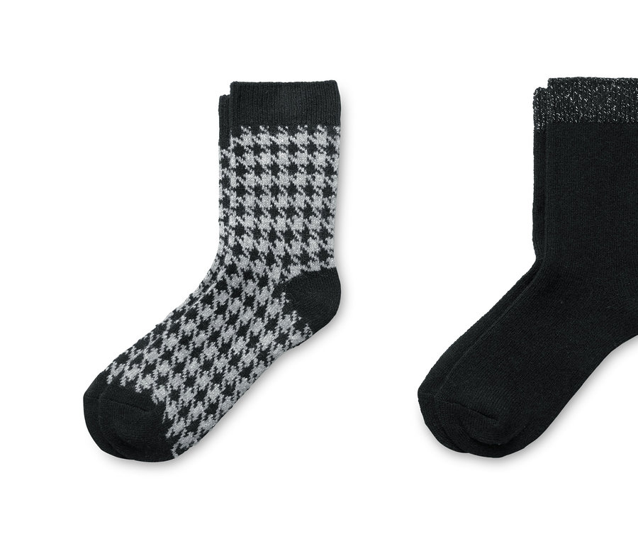 Zwei Paar Socken mit Wollanteil. Ein Paar ist schwarz mit Hahnentrittmuster, das andere Paar ist schwarz mit silbernem Rand.