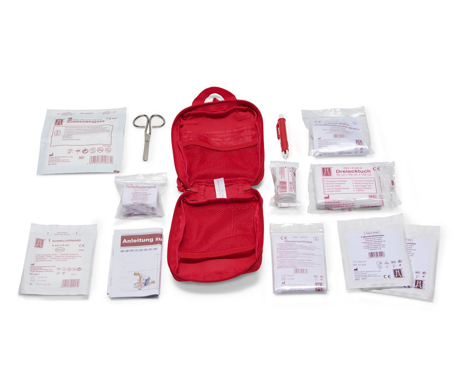 Geöffnete rote Erste-Hilfe-Tasche mit Inhalt.