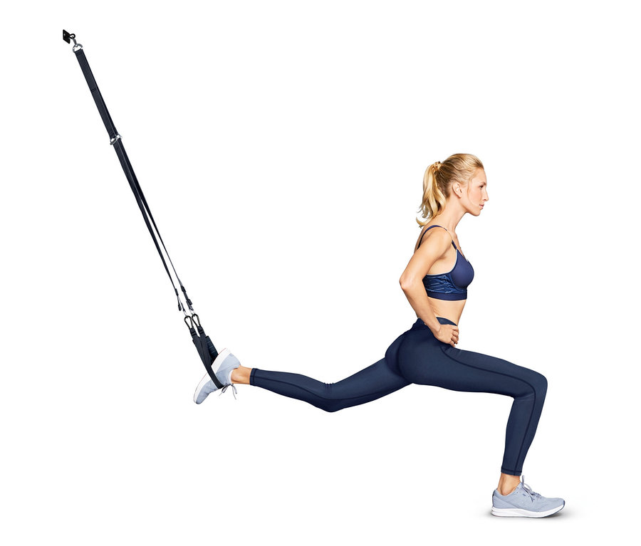 Frau macht Ausfallschritte mit einem Schlingentrainer.