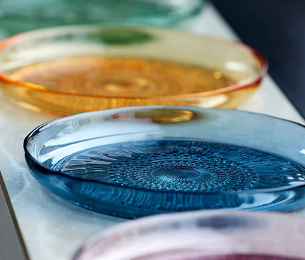 Vier Bitz Glasteller »Kusintha«, 18 cm, grün, orange, blau und rosa auf einem weißen Regal.