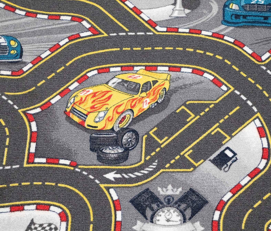 Detailaufnahme eines Kinderteppichs »CARS« mit Rennstreckenmuster und Autos.