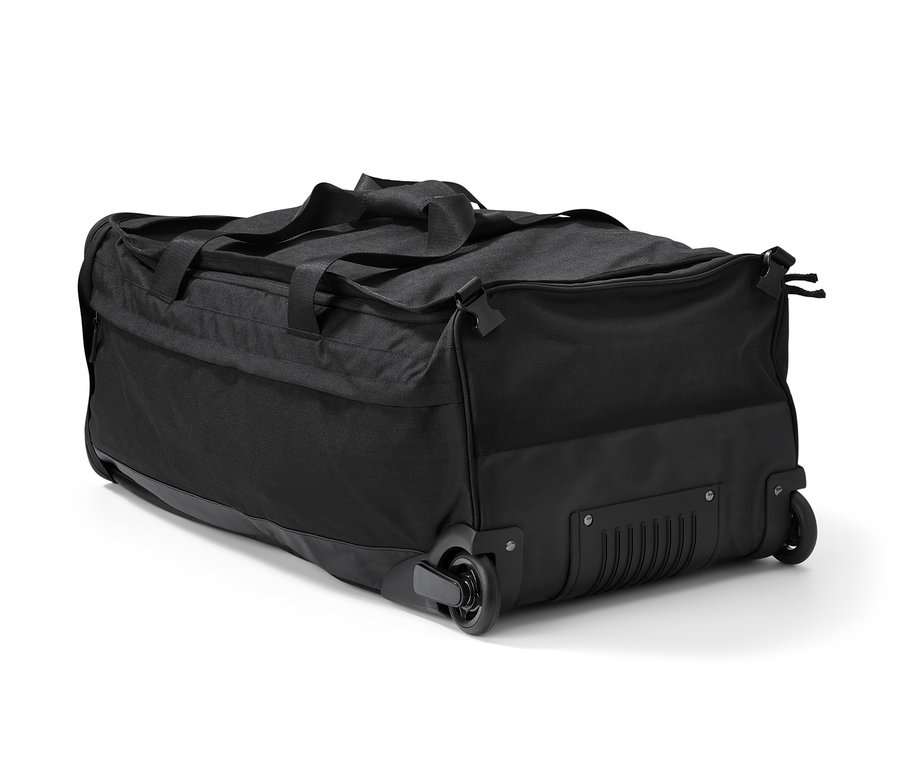 Eine schwarze Rollentasche mit Rucksackfunktion liegt auf der Seite.