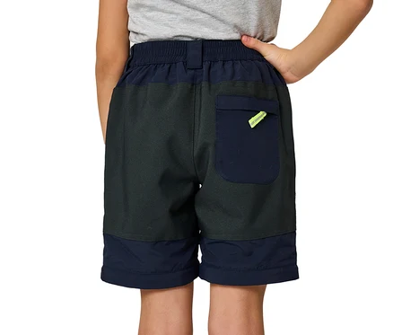 Rückenansicht eines Kindes, das ein graues T-Shirt und zweifarbige Jako-O Shorts in Dunkelgrau und Marineblau trägt. Die Shorts haben eine marineblaue Gesäßtasche mit einem neongelben Detail.