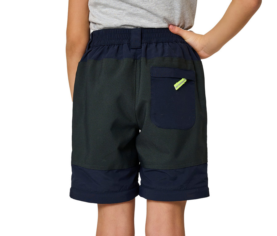 Ein Junge steht mit dem Rücken zur Kamera und trägt marineblaue Jako-O Zipp off Hose.