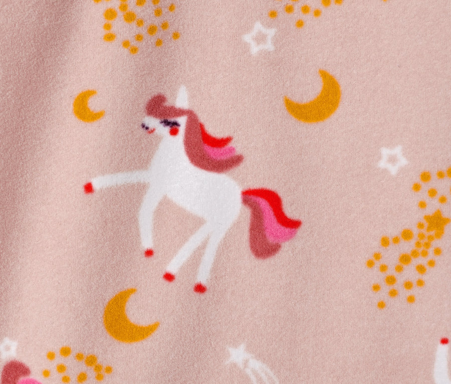 Nahaufnahme einer Kinder-Fleecejacke mit Einhorn-, Stern- und Mondmotiven auf rosa Hintergrund.