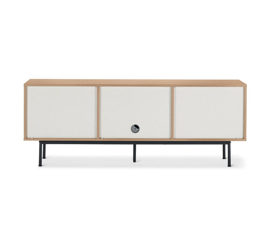 Ein Lowboard »Finnsbo« mit Lamellenoptik, drei weißen Türen und einem hellen Holzrahmen steht auf schwarzen Füßen.