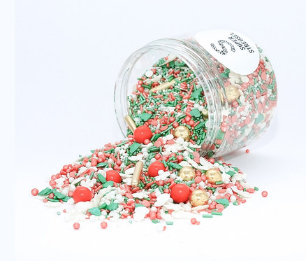 Offenes Glas Super Streusel Zuckerstreuselmix » Klingglöckchen « wird auf eine weiße Oberfläche verschüttet.