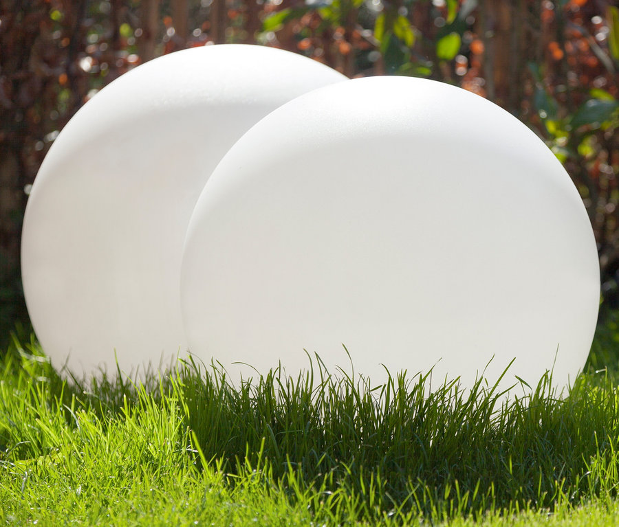 Zwei weiße 8 seasons design Solar-Leuchtkugeln, 60 cm, liegen im Gras.