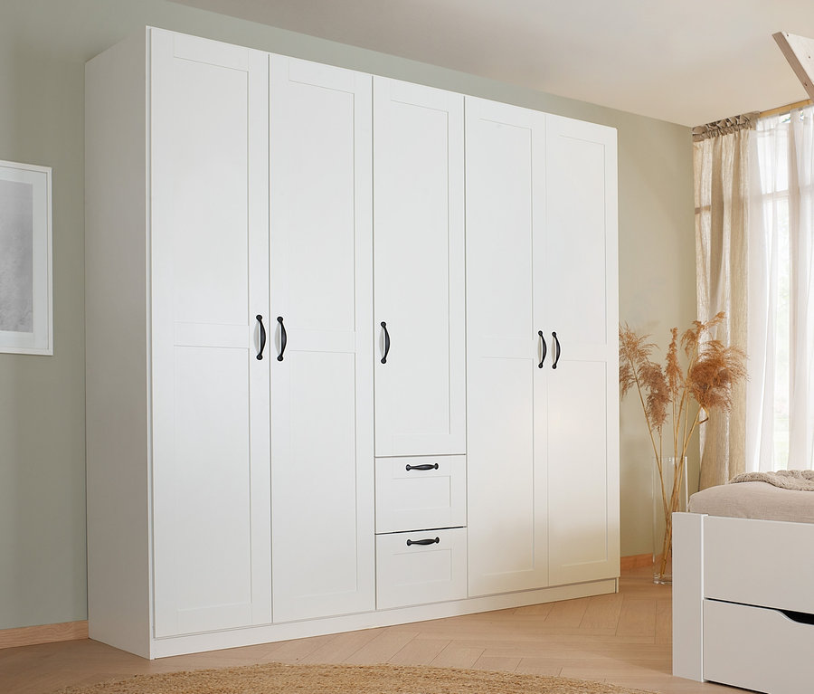 Schlafzimmer mit weißem rauch Drehtürenschrank »Cottage« und Bett.