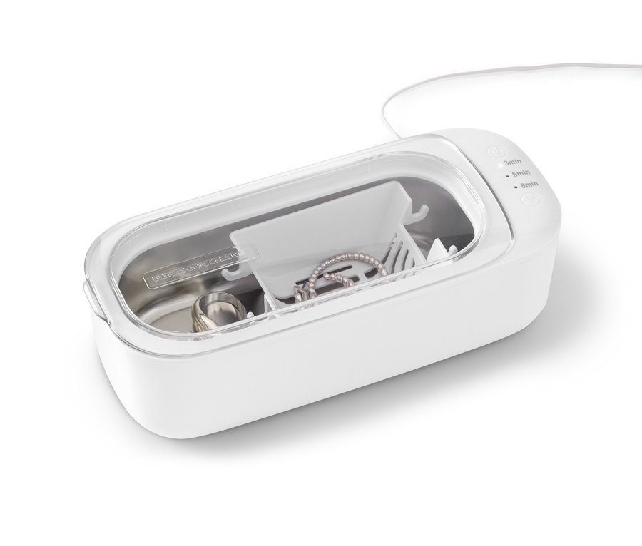 Schmuckstücke liegen in einem Ultraschallreiniger.