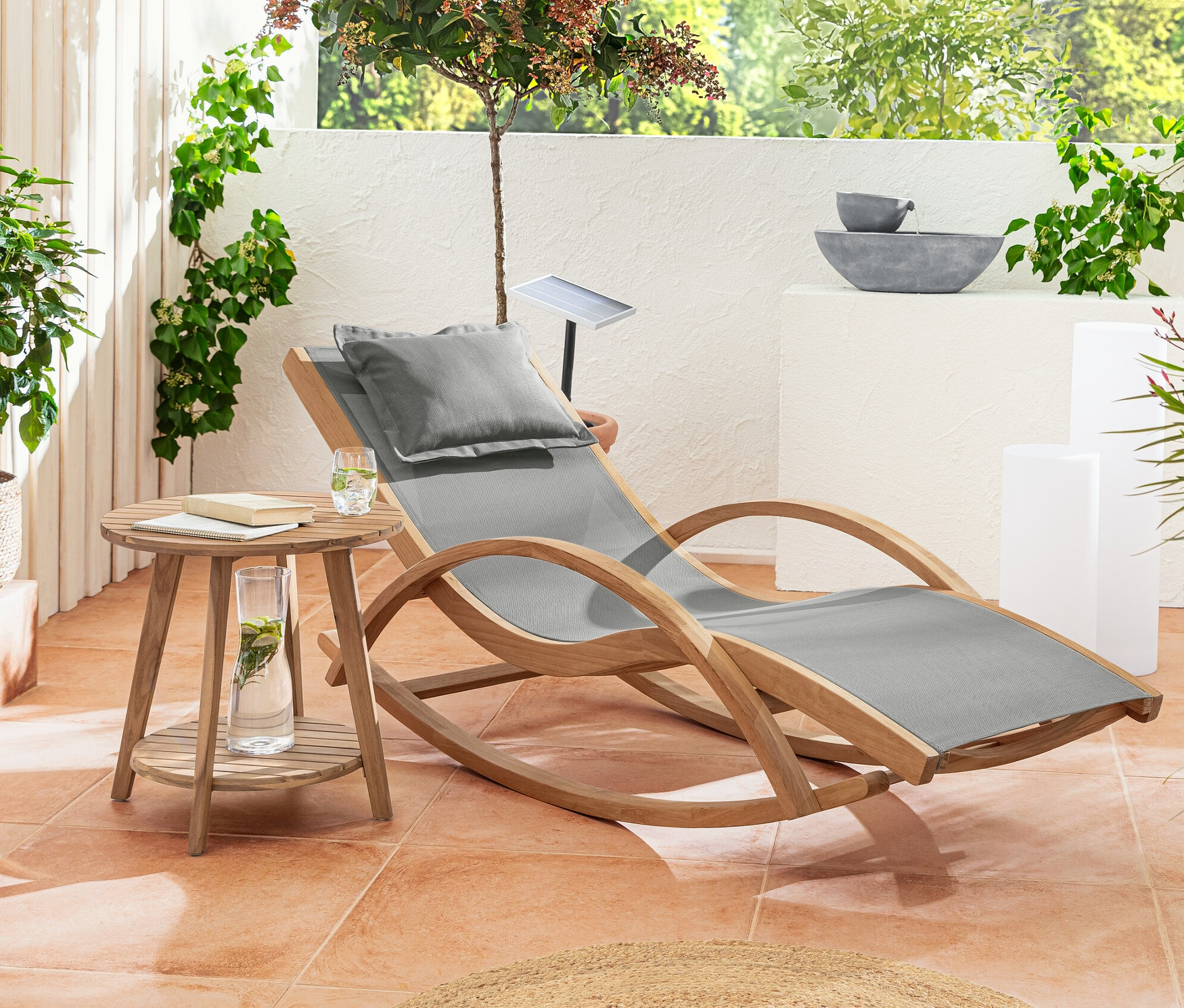 Auf einer Terrasse stehen eine Teak-Schaukelliege, ein Beistelltisch mit 2 Ebenen »Lenja« und eine Solar-Lichtsäule mit Farbwechsel, ca. 50 cm.
