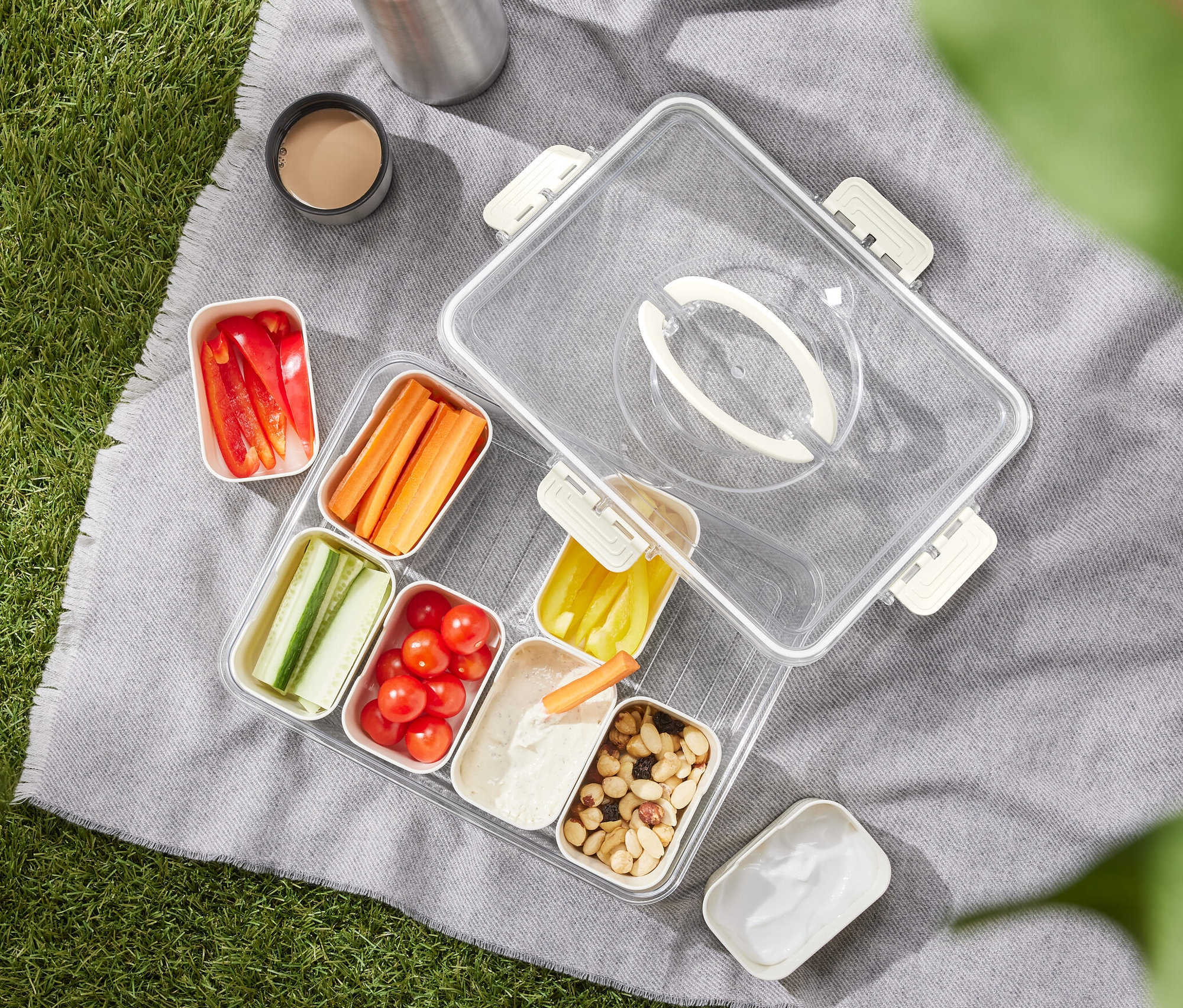 Ein Snacktray to go mit geschnittenem Gemüse auf einer Decke.