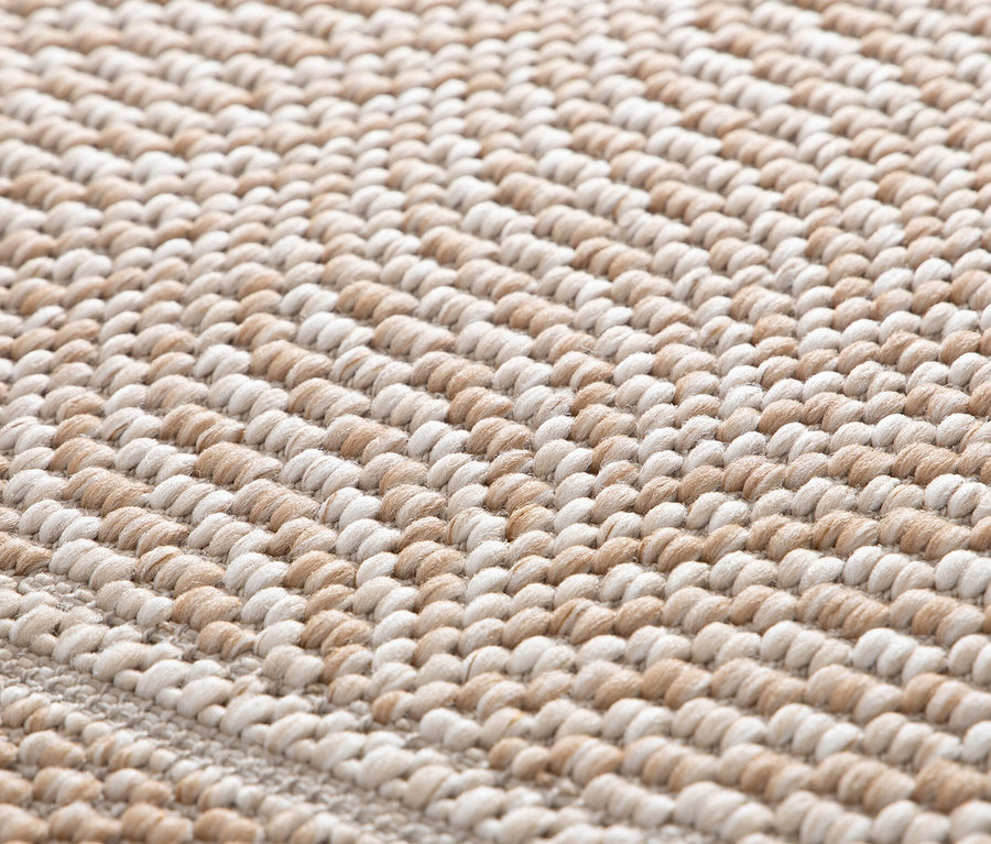 Nahaufnahme eines beigen Teppichs »Twine« mit Fischgrätenmuster.