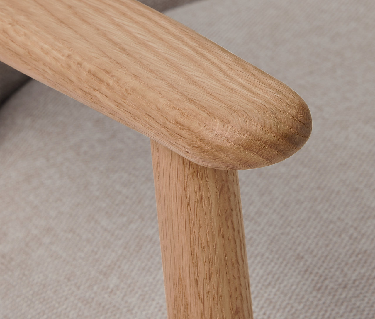 Detailaufnahme eines Sessels mit Armlehnen und Holzgestell.