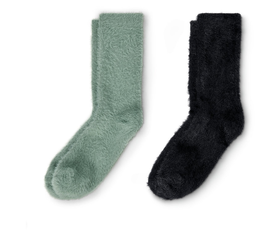 Ein Paar grüne und ein Paar schwarze Kuschelsocken mit Effektgarn liegen nebeneinander.