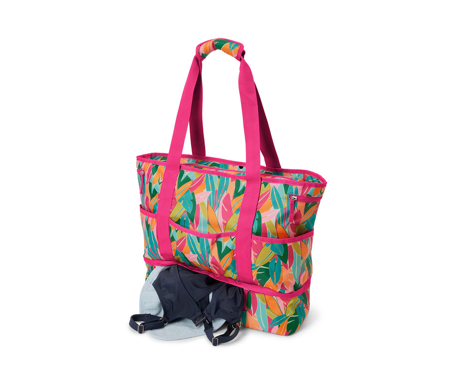 Eine Strandtasche mit Alloverprint. In der Tasche befindet sich ein blauer BH.
