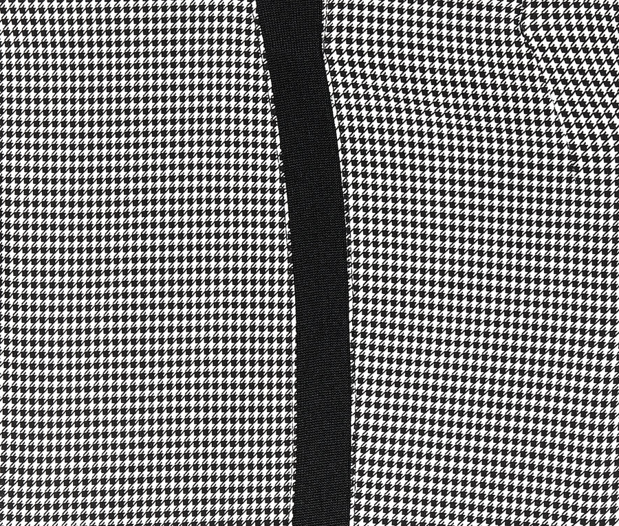 Detail einer knöchellangen Stretchhose mit Hahnentrittmuster und schwarzem Streifen.