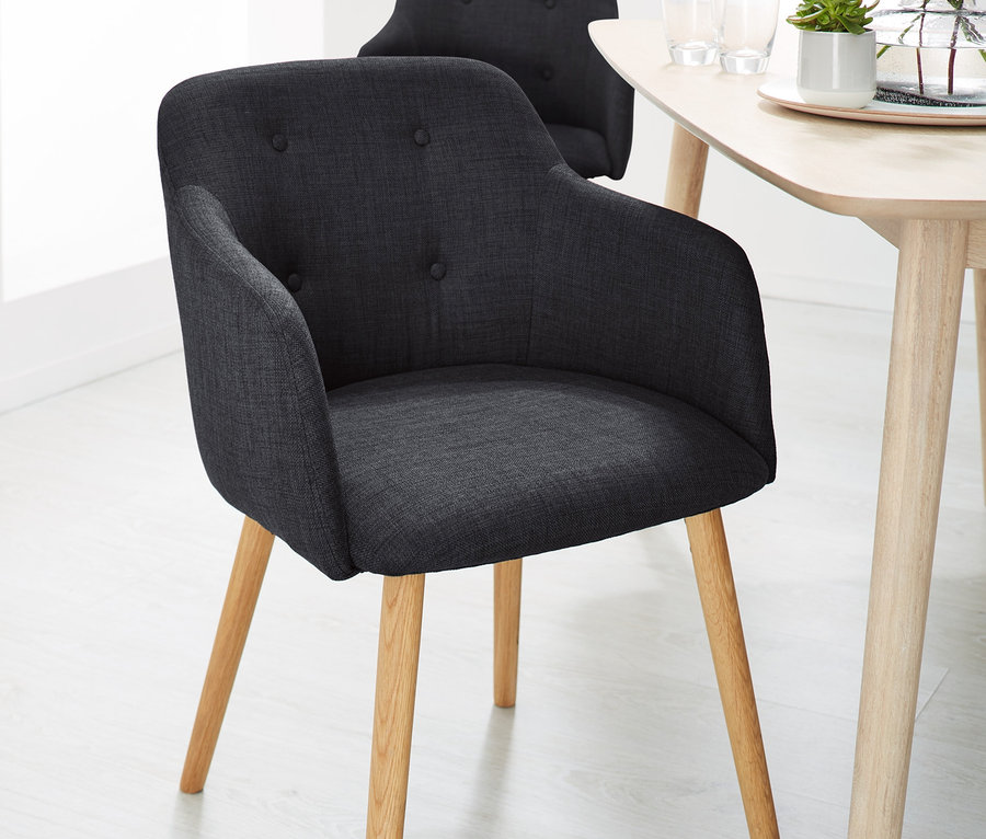 Zwei anthrazitfarbene, gepolsterte Stühle an einem Tisch.