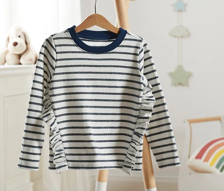 Gestreiftes Sweatshirt mit Glitzerdetails hängt auf einem Holzbügel.