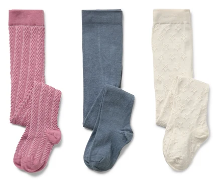 Drei Paar Kinderstrumpfhosen: rosa mit Zopfmuster, blau glatt und creme mit Sternen.