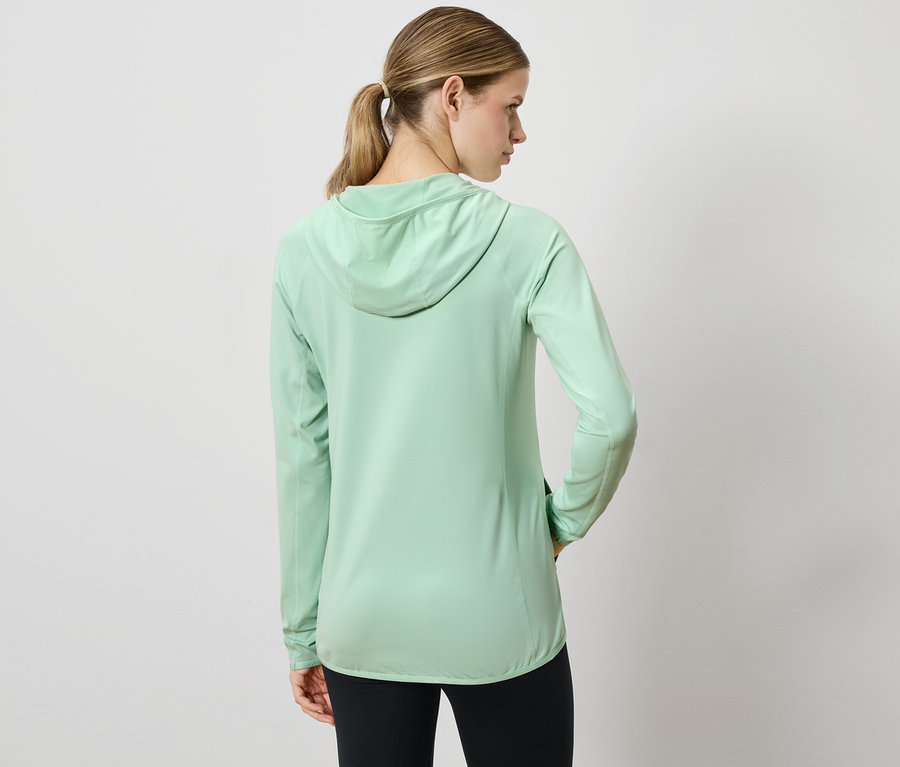 Frau mit dem Rücken zur Kamera trägt ein hellgrünes Kapuzensweatshirt und schwarze Leggings.