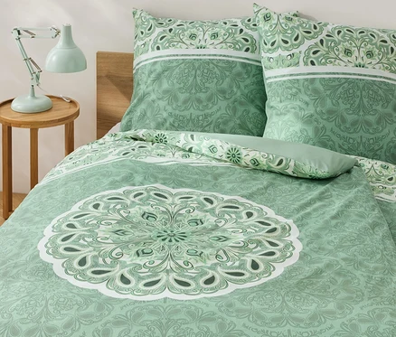 Grüne Renforcé-Bettwäsche mit Mandala auf einem Bett.