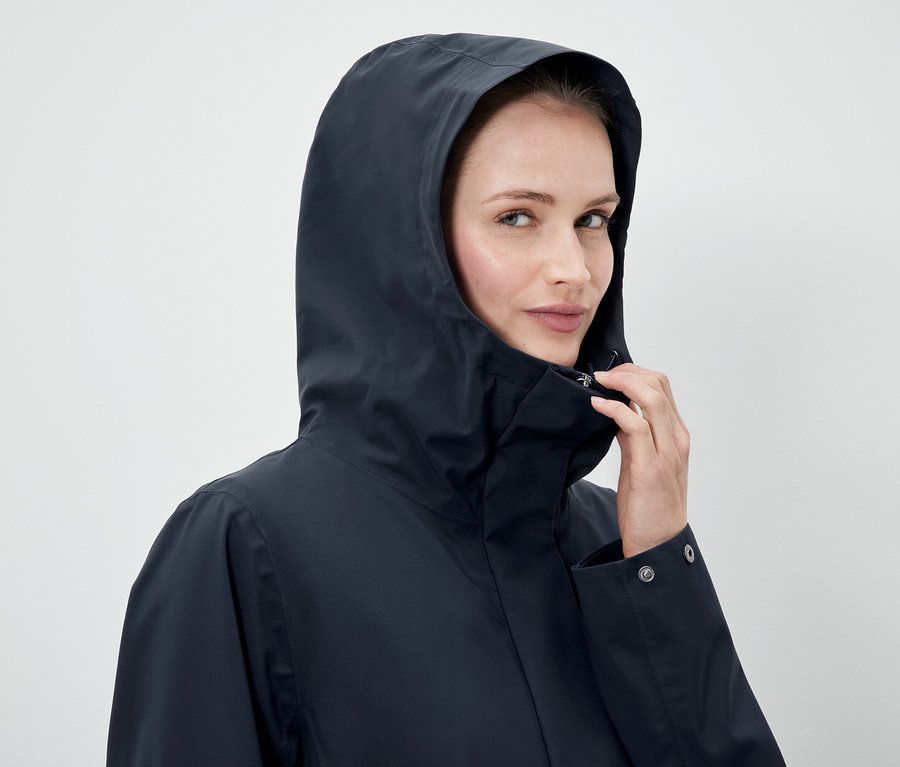 Frau trägt eine dunkelblaue Jacke mit Kapuze.