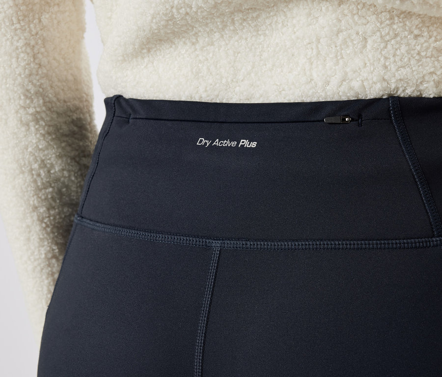 Detailaufnahme von schwarzen Damen-Leggings mit der Aufschrift "Dry Active Plus" und einer Reißverschlusstasche oben.