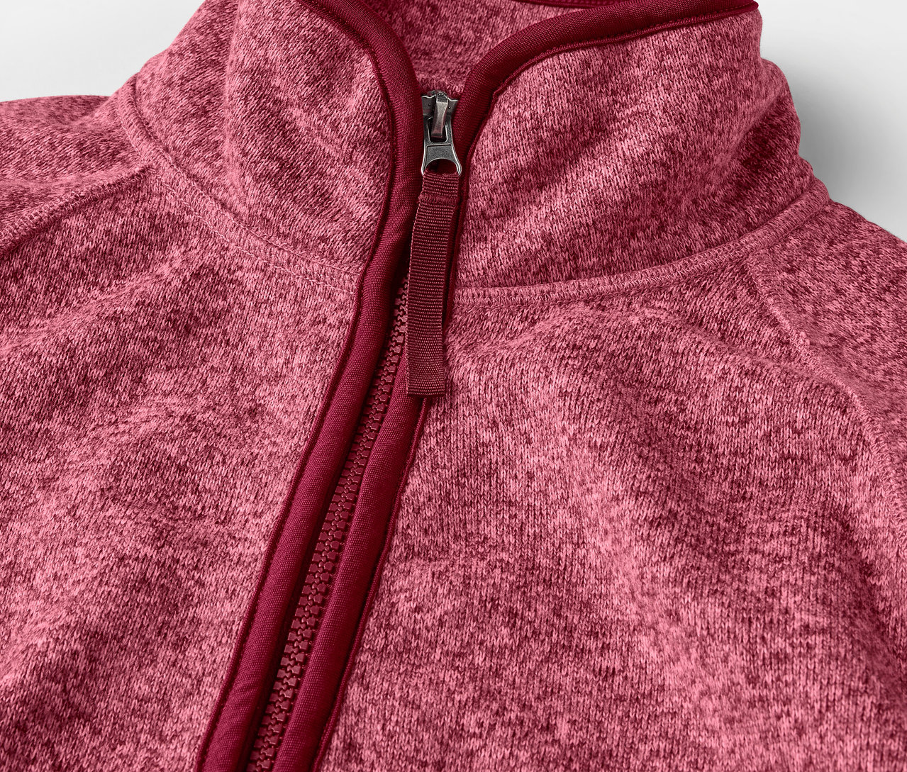 Detailansicht einer rosa Strickfleece-Jacke mit Reißverschluss.