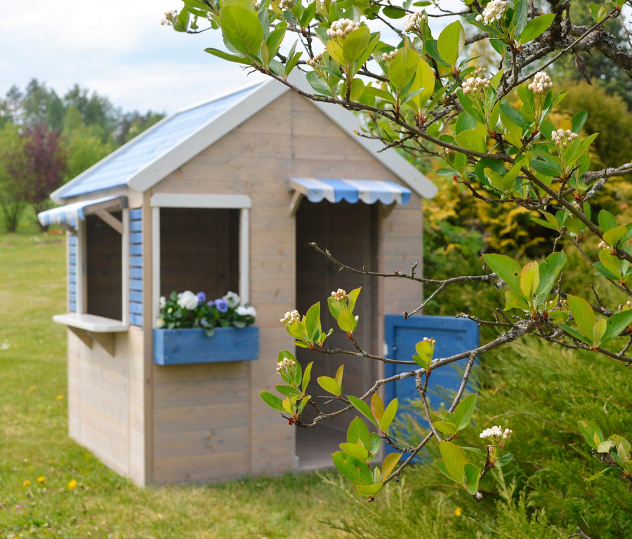 Auf einer Wiese steht ein braunes und blaues Kinderspielhaus, Wendi-Spielhaus »Maritime House«.