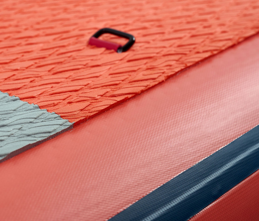 Detailaufnahme eines orangefarbenen Aqua Marina SUP Boards »Atlas« 12' 0" mit grauer Antirutschmatte und schwarzem Haltegriff.