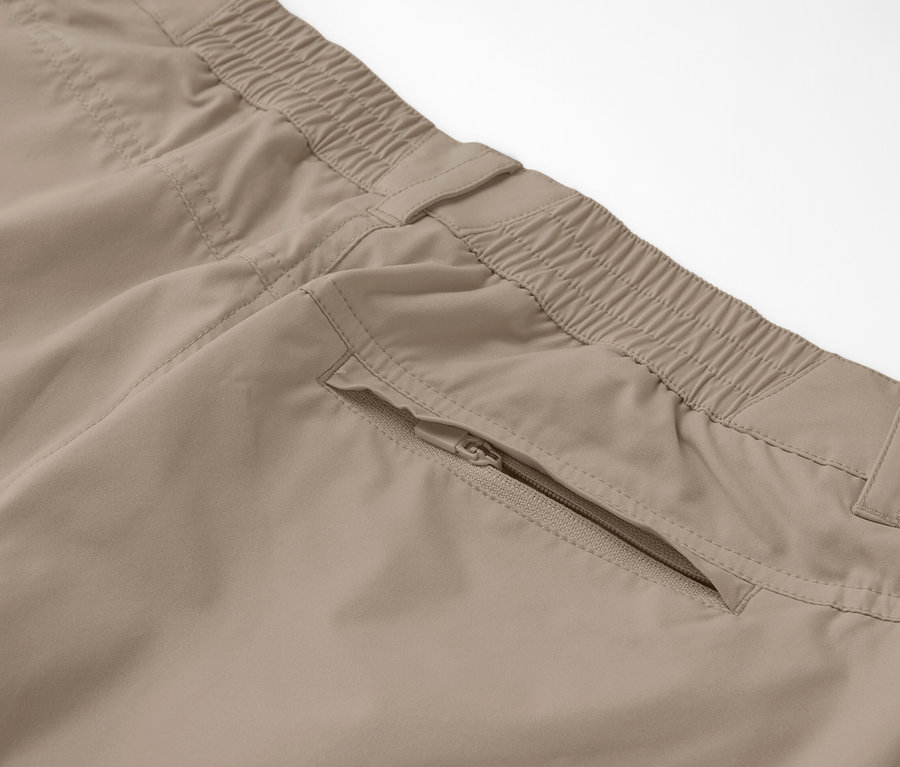 Detailaufnahme einer beigen 2-in-1-Funktionshose mit Reißverschlusstasche.