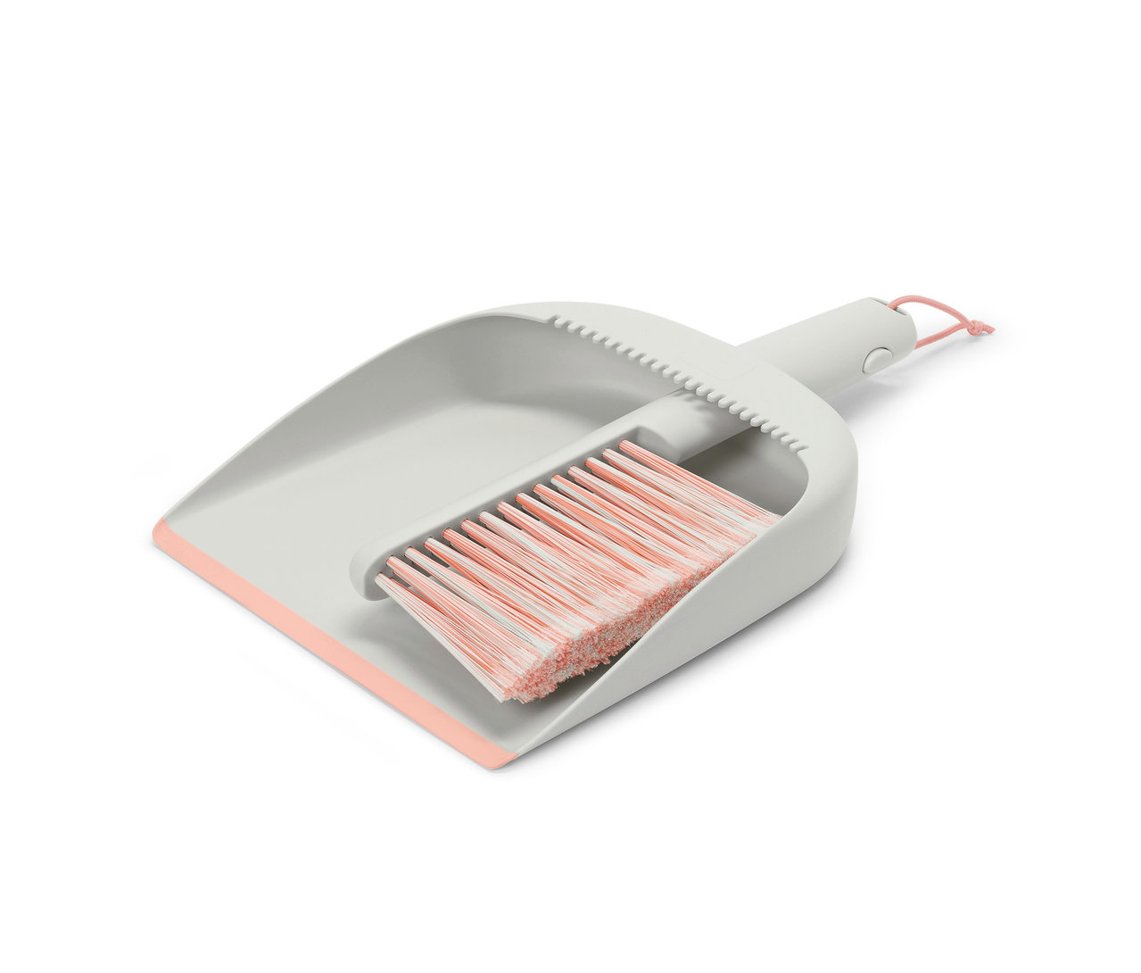 Ein grauer Handkehrer und eine Schaufel mit rosa Details.