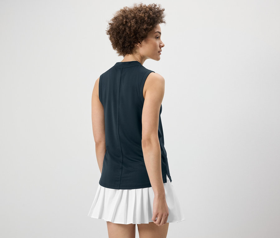 Frau von hinten trägt ein dunkelblaues Funktionstop und einen weißen Rock.