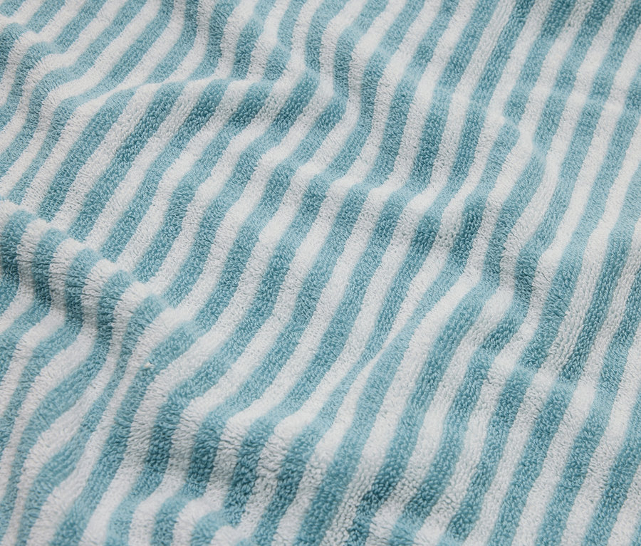 Nahaufnahme eines blau-weiß gestreiften Frotteehandtuchs.