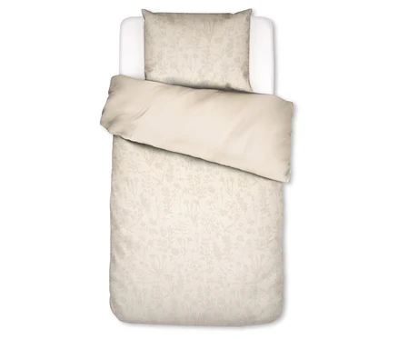 Eine Essenza Bettwäsche «Maribel» in Normalgröße auf einem Einzelbett. Das Kopfkissen und der Bettbezug sind hellbeige mit einem dezenten Blumenmuster. Der obere Teil des Bettbezugs ist zurückgeschlagen und zeigt eine unifarbene hellbeige Unterseite.