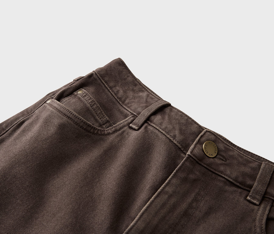 Nahaufnahme einer braunen Jeans mit Knopfverschluss und Hosentasche.